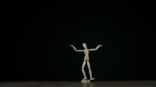 Wooden Figure Dummy in Studio on Black Background Rotates