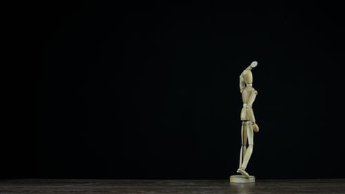 Wooden Figure Dummy in Studio on Black Background