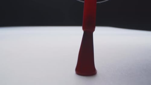 Red Nail Polish Brush Stroke on White Surface