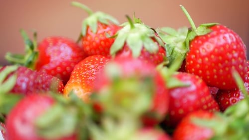 Frische Erdbeeren in einer Schüssel auf orangefarbenem Hintergrund