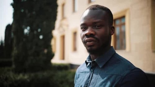 Handsome African American Man Turns To the Camera Standing on the Street