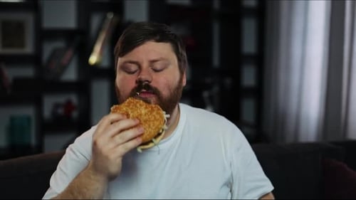 Bearded Man Eating a Burger and Drinking
