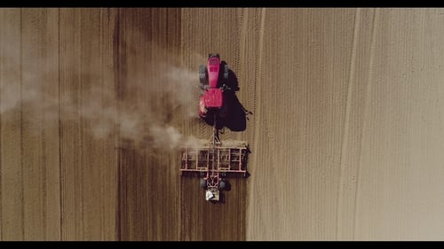 Aerial of Tractor on Harvest Field Ploughing Agricultural Field.
