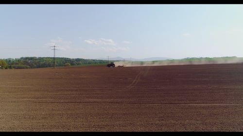 Aerial of Tractor on Harvest Field Ploughing Agricultural Field.