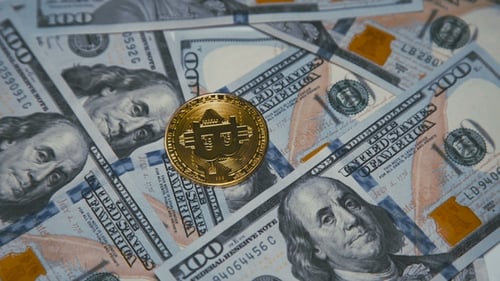 Golden Bitcoin Revolving on Bills of 100 Dollars