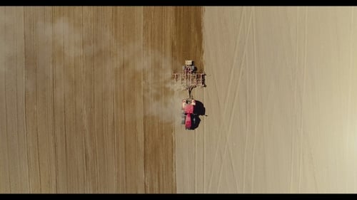 Tractor trabajando en un hermoso y espacioso campo agrícola