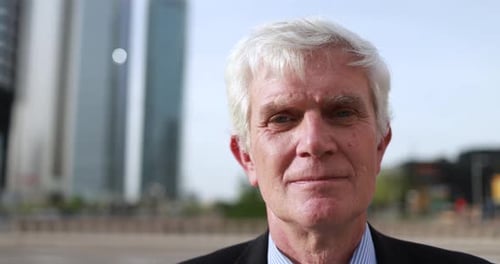 Senior business man working outside of the office with city in background