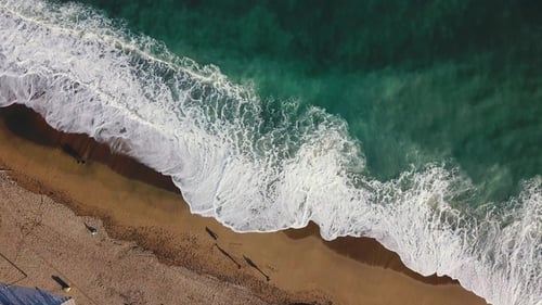 Sand Beach Stock, Top View of a Beautiful Sandy Beach with the Blue Waves Rolling Into the Shore
