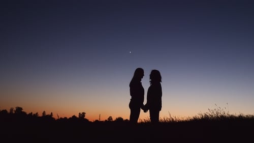 Silhouette Lesbisches Paar küsst sich bei Sonnenuntergang