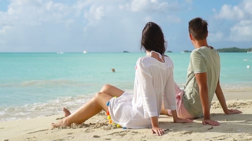 Young Couple on White Beach During Summer Vacation. Happy Lovers Enjoy Their Honeymoon at Exotic