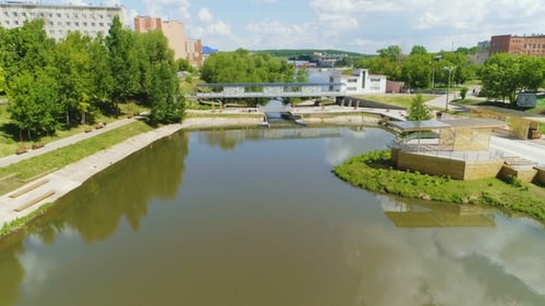 River Flows Across City and Surrounded with Green Plants