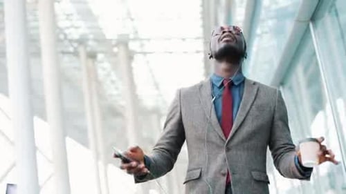Smiling Man Listens to Music and Walks