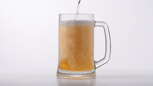 Beer Pouring Into a Clear Glass Mug