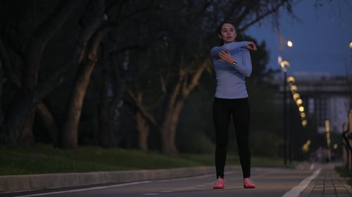 Stretching Before Starting Workout. Young Sporty Girl Warms Up Before Jogging on the Evening Park