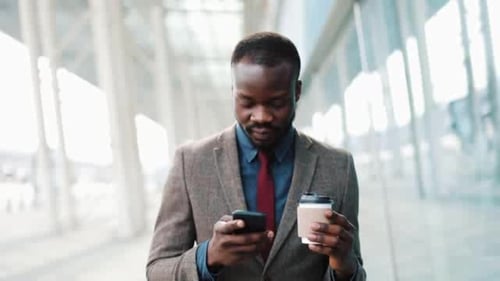 Young African Americanman Using App on Smartphone in City Near the Office Center Handsome Young