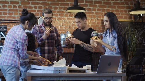 Colleagues in Office Eating Pizza Together