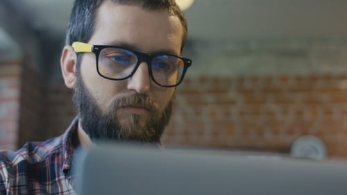 Bearded Man Uses Laptop in Office