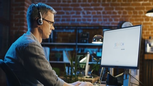 Mann im Headset surft im Internet im Büro