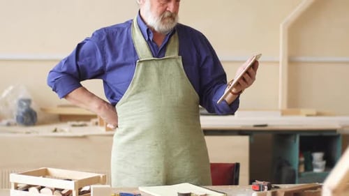 Carpenter Holding Tablet in Wood Shop