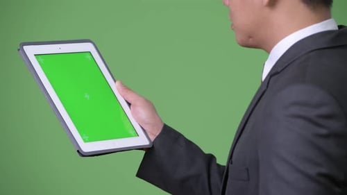 Man in Suit Using Green Screen Tablet