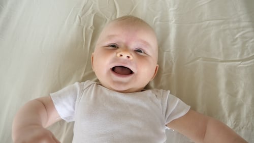 Baby Giggles While Being Tickled Indoors on Blanket