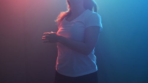 Young Modern Style Dancer on a Dark Background with Smoke and Lights