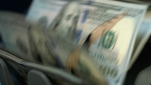 Money Counting Machine Processing Stacks of Dollar Bills