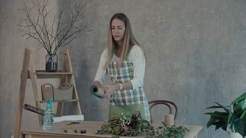 Woman Arranges Bouquet with Kraft Paper at Table