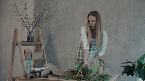 Florist Wrapping Flowers in Paper at Flower Shop