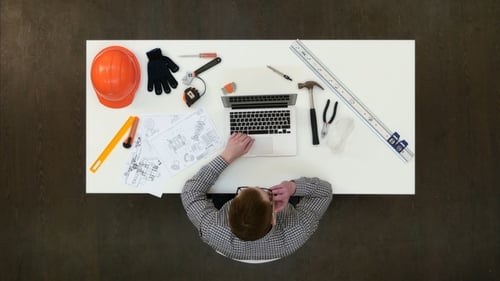 Architekt im Büro, der am Laptop arbeitet und Telefonanrufe entgegennimmt
