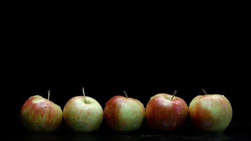 Rote und gelbe Äpfel unter sauberem Wasser spritzen mit Tröpfchen in der Küche