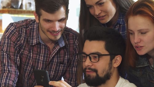 Group of Friends Using Smart Phone Together at the Coffee Shop