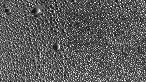 Drops of Condensate Flow Down the Glass.