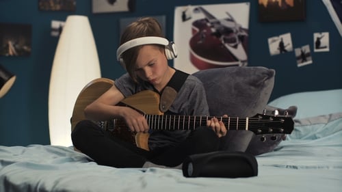 Boy Plays Electric Guitar in Bedroom