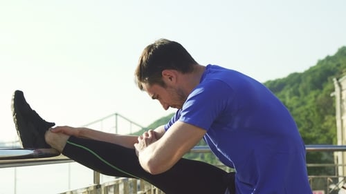 Man Stretching Leg on Urban Overlook