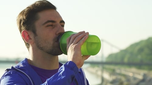 Young Adult Man Drinking Water Outdoors