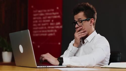 Tired of Working on the Laptop Young Businessman Pushes Up His Glasses and Rubs His Eyes