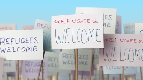 Los refugiados reciben carteles en la manifestación callejera