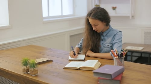 Young Girl with Laptop Computer Is Doing Homework. College Education