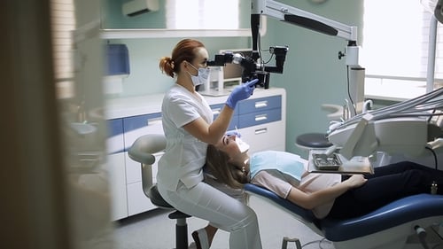 Dentist Examines Patient with Microscope in Clinic