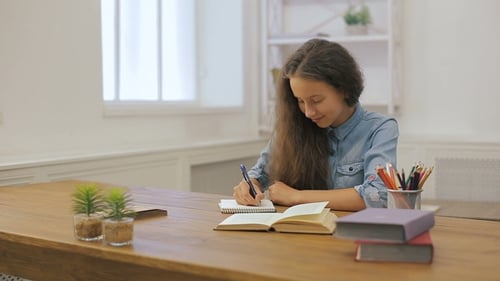 Young Girl with Laptop Computer Is Doing Homework. College Education. Female Student Is Studying