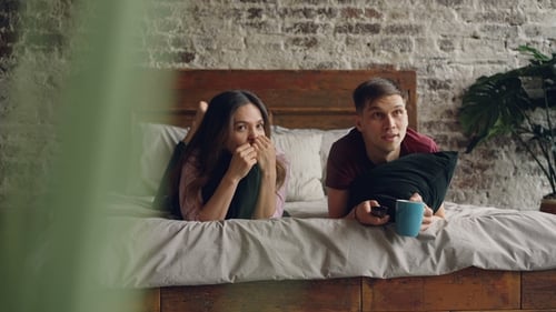 Couple Relaxing and Watching in Bedroom