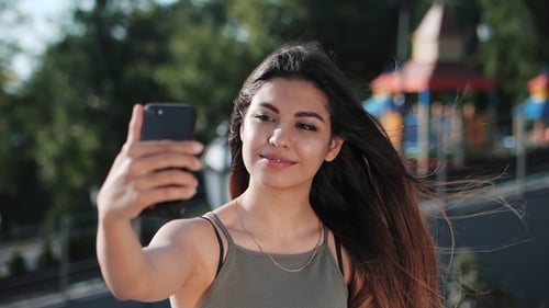 Young Woman Takes Selfie in Urban Park