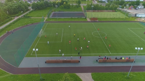 Green Soccer Field. Players Playing Football. Aerial View. Flying Sideways