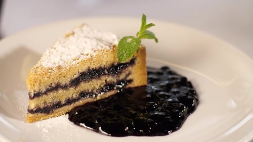 Slice of Blueberry Crumble Cake with Mint Garnish
