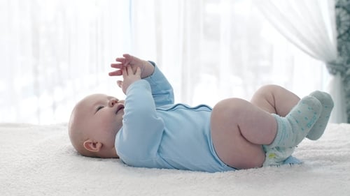 Infant Lying on Back Smiling in Bright Light