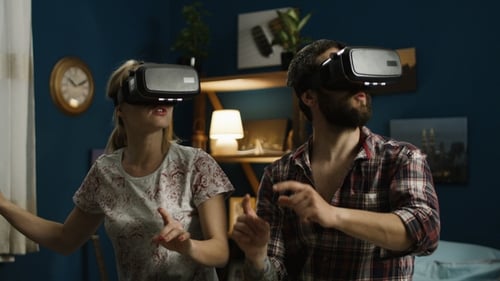 Couple Wearing VR Headsets Experiencing Virtual Reality