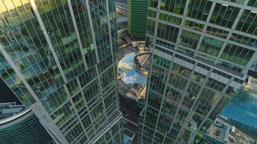 Flying Up Between Two Modern Tall Skyscrapers with Offices and Apartments in Morning. Aerial View