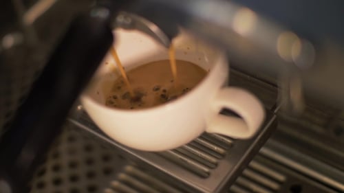 Coffee Pouring Into Cup From Coffee Machine in Restaurant