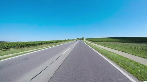 Car Drives on Asphalt Road Through Rural Countryside